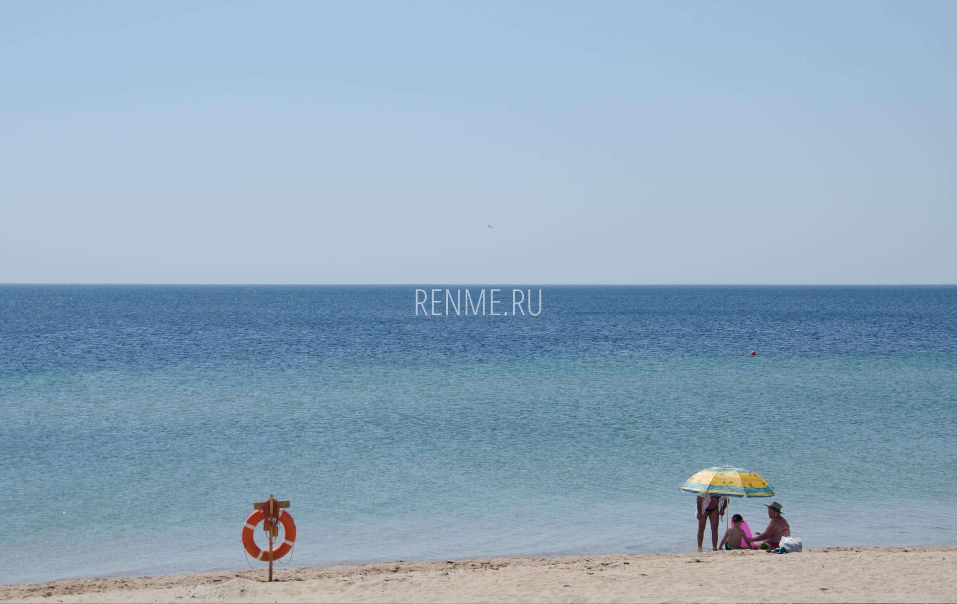 Отдыхающие в зонтиком на пляже в июле. Фото Заозёрного